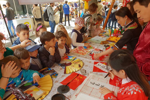 1527053152641862.jpg 当地孩子们一边玩游戏一边等待我孔子学院老师为其书写中国名字.jpg